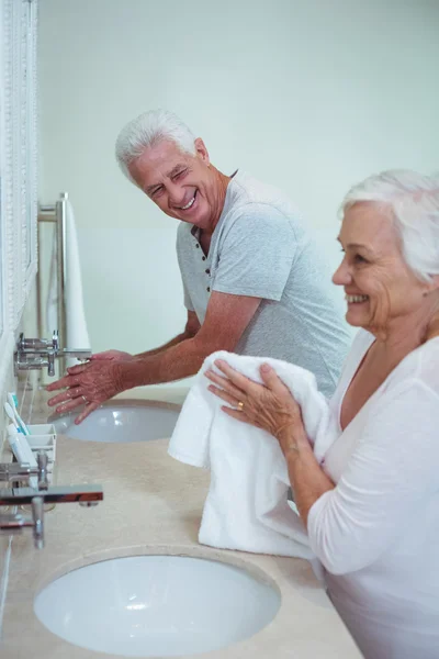 Couple cleaning hands in bathroom — Stock Photo, Image