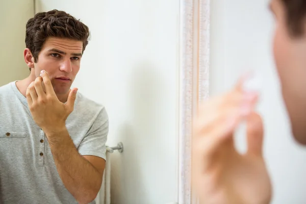 Homme appliquant une crème hydratante sur le visage — Photo