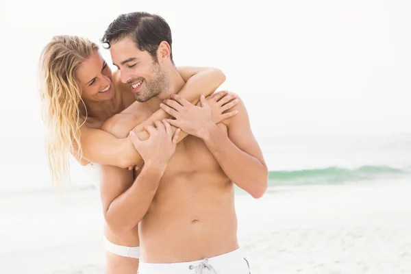 Gelukkige paar omarmen op het strand — Stockfoto