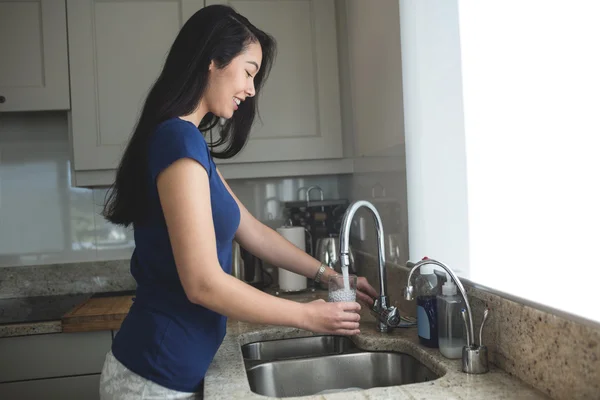 Mujer lavando vidrio en fregadero de cocina — Foto de Stock