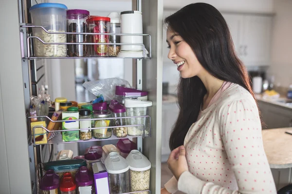 Woman looking into storage cabinet — Stock Photo, Image