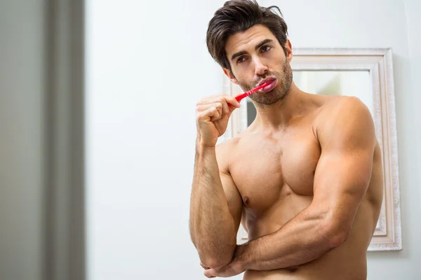 Genç adam dişlerini fırçalıyor. — Stok fotoğraf