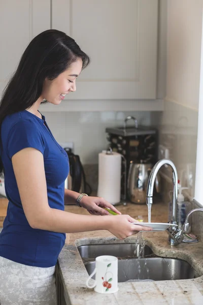 Mulher lavando a louça na cozinha — Fotografia de Stock