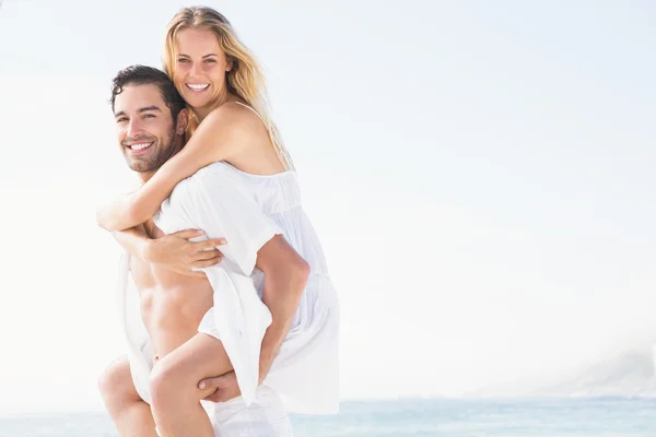 Boyfriend giving piggy back to girlfriend — Stock Photo, Image