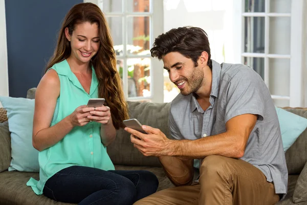 Paar kijken naar telefoon en glimlachen — Stockfoto