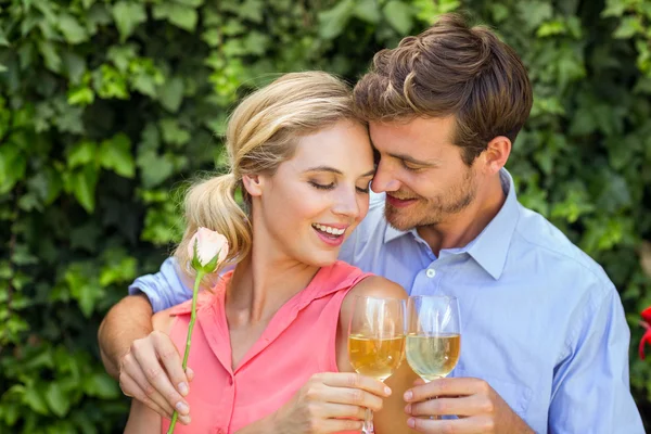 Paar umarmt sich beim Anstoßen auf Weingläser — Stockfoto