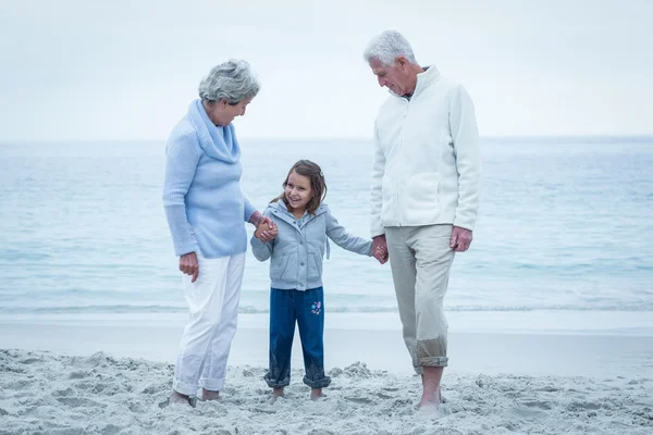 Großeltern mit Enkelin am Strand — Stockfoto