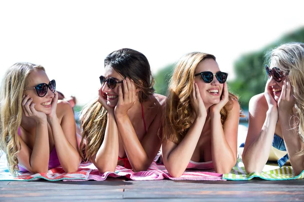 Grupo de amigos deitados perto da piscina — Fotografia de Stock