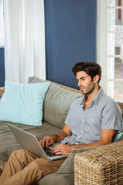 Mężczyzna korzystający z laptopa w salonie — Zdjęcie stockowe