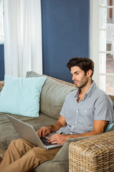 Hombre usando el portátil en la sala de estar — Foto de Stock