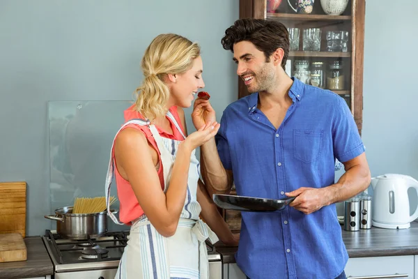 Uomo che nutre donna in cucina — Foto Stock