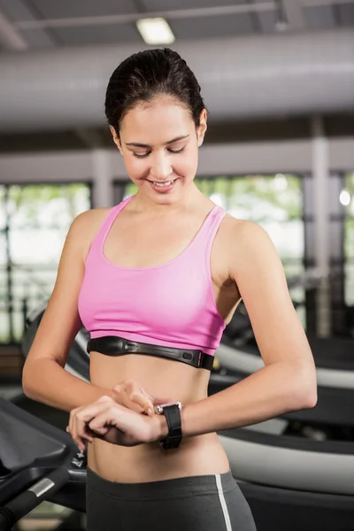 Woman using smart watch on treadmill