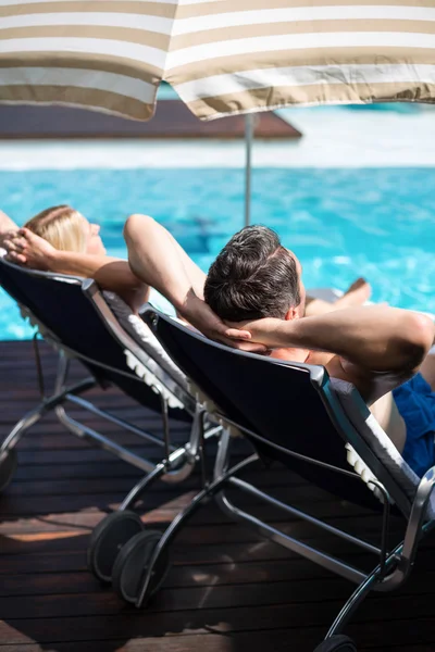 Couple relaxing on sun lounger — Stock Photo, Image