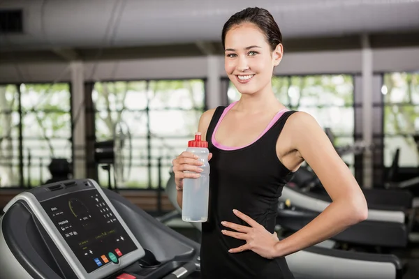 Vrouw op loopband holding waterfles — Stockfoto