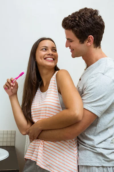 Paar knuffelen tijdens het tandenpoetsen — Stockfoto