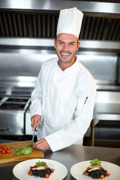 Handsome chef slicing garnish — Stock Photo, Image