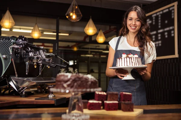 Barista holding plate with cake — Stock Photo, Image