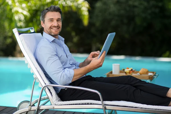 Man met digitale tablet bij zwembad — Stockfoto