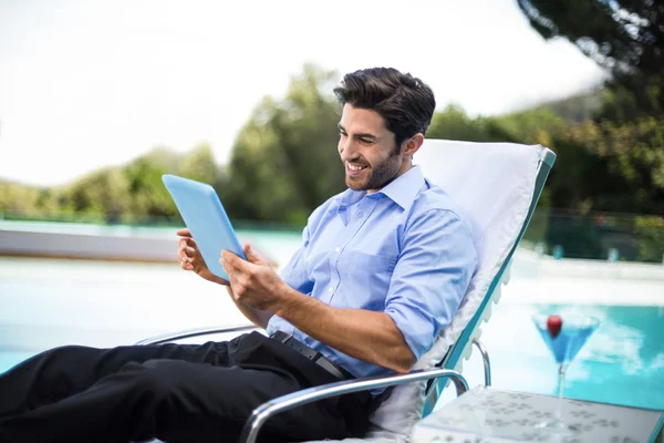 Slimme man met behulp van Tablet PC in de buurt van zwembad — Stockfoto