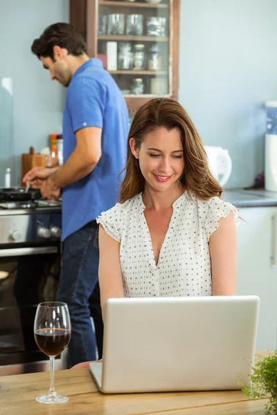 Mulher usando laptop na cozinha — Fotografia de Stock