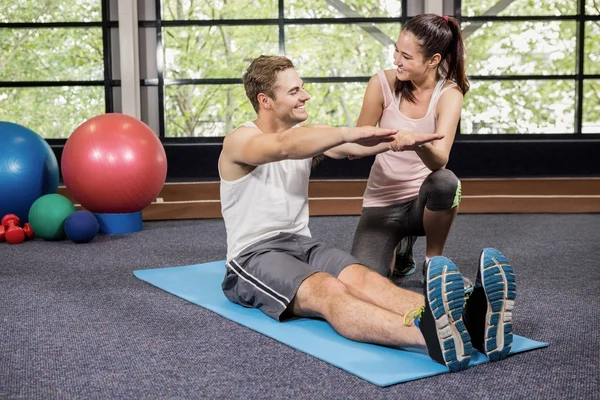 Trainer motivating man while doing crunches — Stock Photo, Image