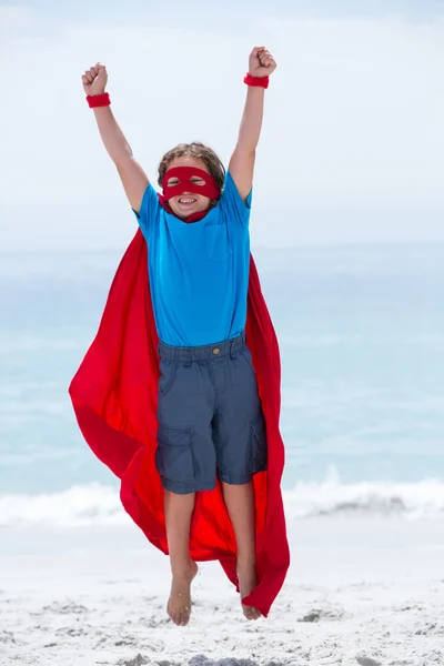 Junge im Superheldenkostüm springt — Stockfoto