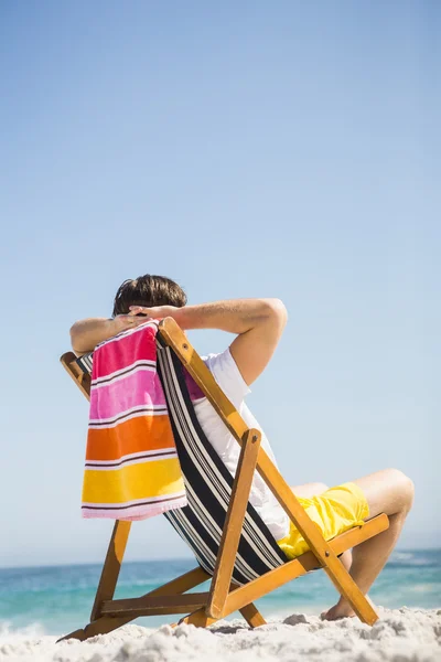 Homem sentado e relaxante na cadeira deck — Fotografia de Stock