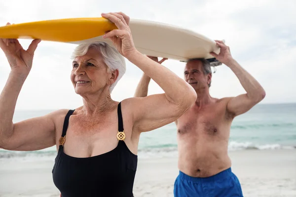 Senior paar dragende surfplank — Stockfoto