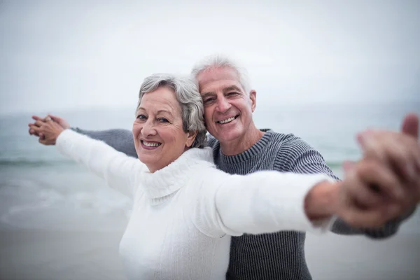 Senior paar met uitgestrekte armen — Stockfoto