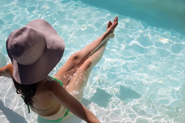 Donna che si gode un bagno di sole in piscina — Foto Stock