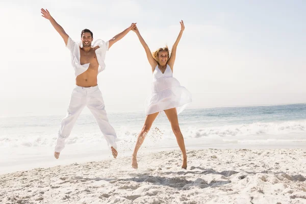 情侣在海滩上跳跃 — 图库照片