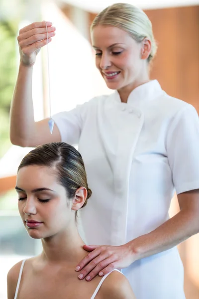 Masseuse bedrijf hanger over hoofd vrouw — Stockfoto