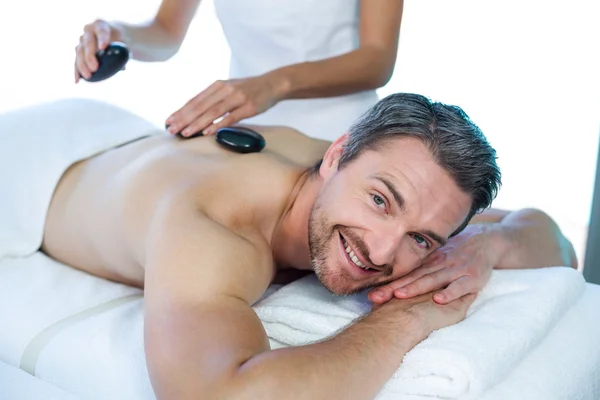 Homem recebendo massagem de pedra quente — Fotografia de Stock