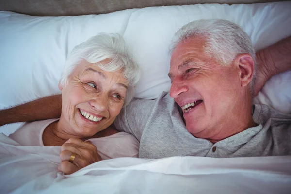 Ridendo coppia anziana sdraiata sul letto — Foto Stock