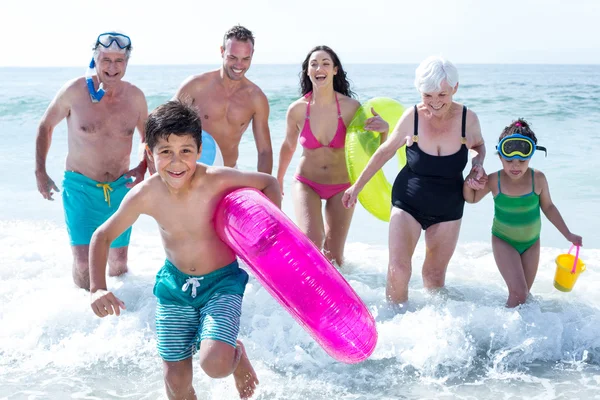 Multi-generation family running at beach — Stock Photo, Image