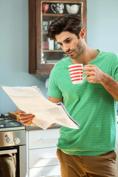 Uomo che legge il giornale mentre prende il caffè — Foto Stock