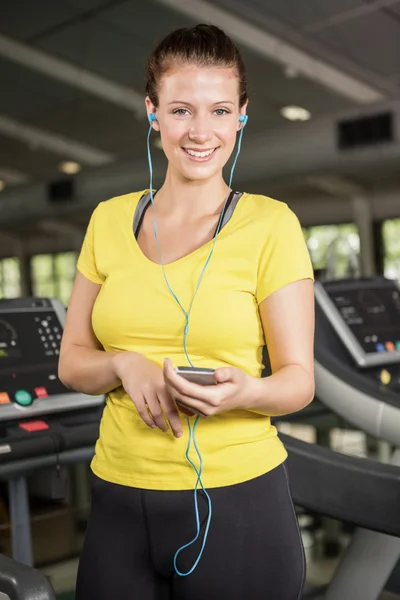 女人在跑步机上听音乐 — 图库照片