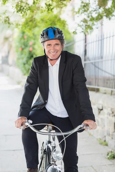 Бизнесмен улыбается на велосипеде — стоковое фото