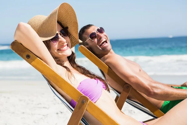 Casal relaxante em cadeiras deck — Fotografia de Stock