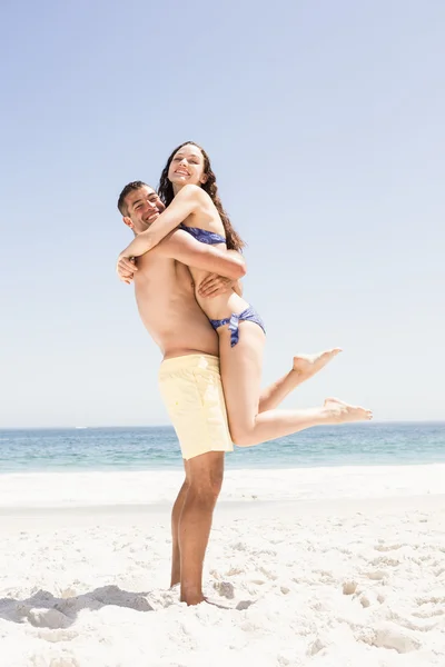 Lachende paar omarmen op het strand — Stockfoto