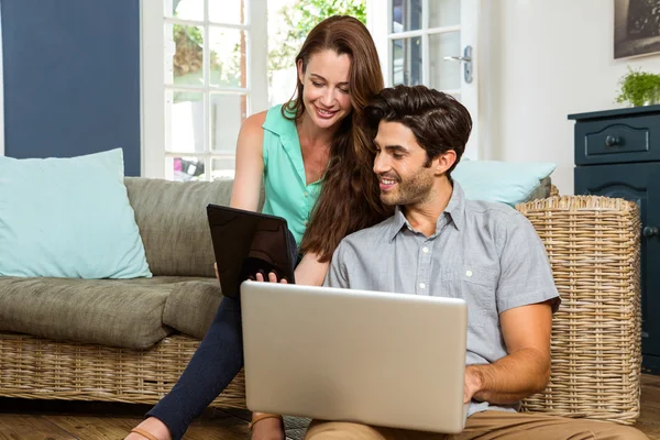 Pareja usando tableta y computadora portátil — Foto de Stock