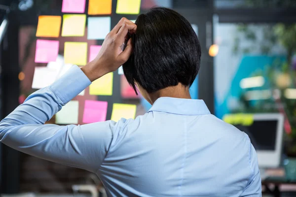 Mujer de negocios preocupada mirando nota adhesiva — Foto de Stock