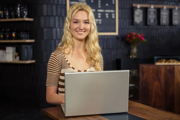 Smiling woman using laptop — Stock Photo, Image