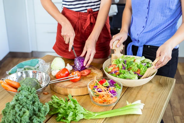 Amis couper des légumes dans la cuisine — Photo