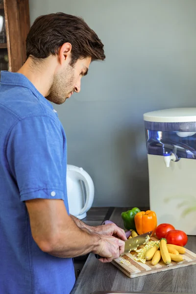 Man hakken van groenten op aanrecht — Stockfoto