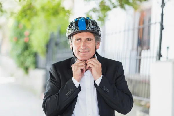 Businessman adjusting helmet — Stock Photo, Image