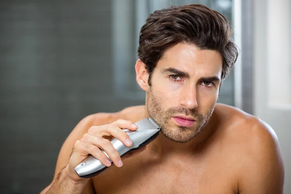 Чоловік голиться з тримером — стокове фото
