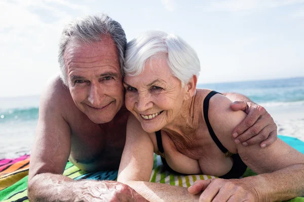 Casal sênior deitado na praia — Fotografia de Stock