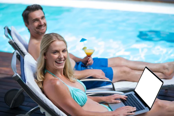 Paret sitter på solstol nära pool — Stockfoto