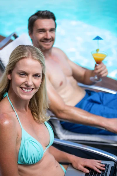 Pareja en la tumbona cerca de la piscina — Foto de Stock